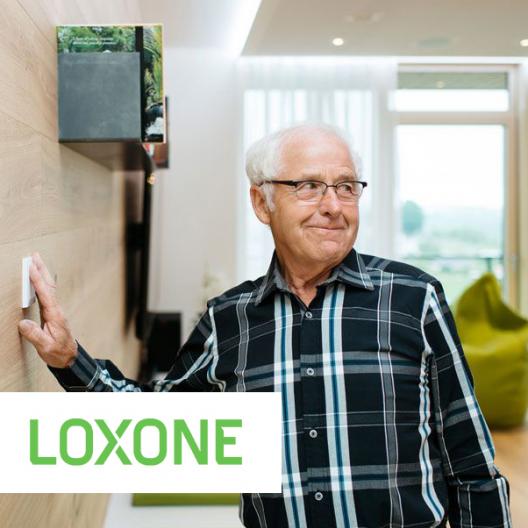Glücklicher, alter Mann mit Loxone Produkt
